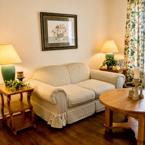 A living room with a couch, a table, and a painting on the wall.