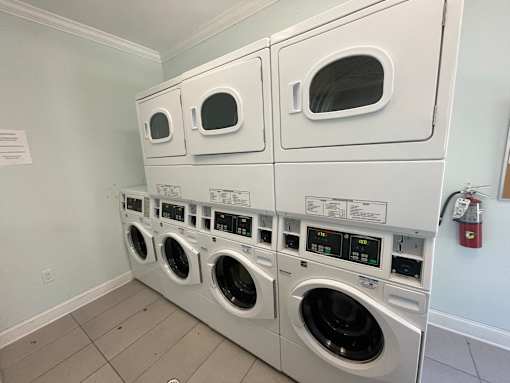 a row of washers and dryers in a laundry room