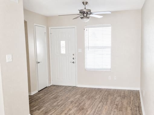 A room with a ceiling fan and two doors.
