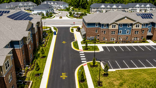A road with a yellow sign that says "STOP HERE ON RED" in front of apartment buildings.