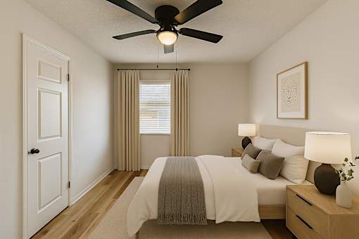 A bedroom with a bed, nightstand, and a ceiling fan.