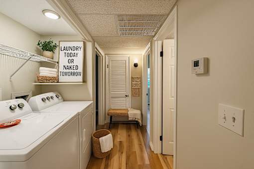 Laundry sign in a hallway with a washer and dryer.