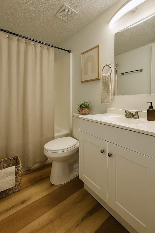 A bathroom with a toilet, sink, and shower curtain.