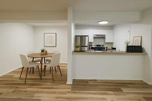 A kitchen with a dining table and chairs.