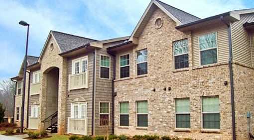 A large stone and siding house with a grey roof.
