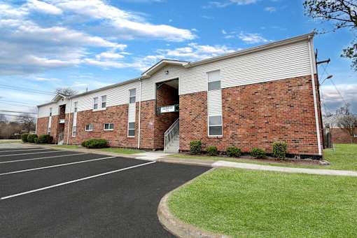 A parking lot is in front of a brick building.
