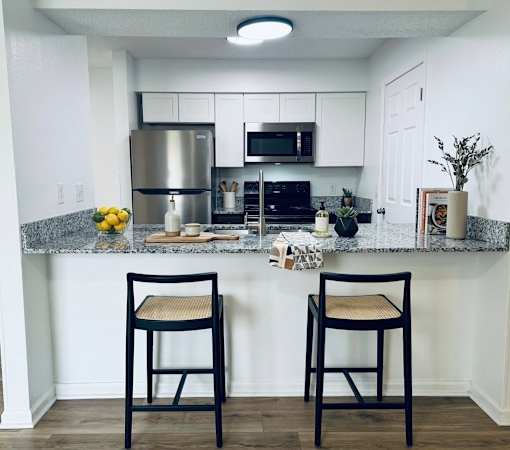 Two black chairs are placed in front of a kitchen counter.