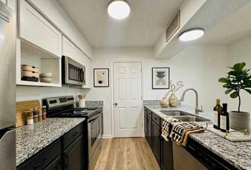 A kitchen with black countertops and white cabinets.