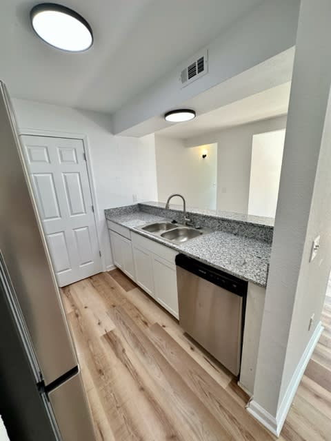 a kitchen with a sink and a dishwasher at Mammoth at the Orchard Apartments, Rogers, AR  