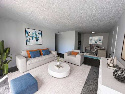 A living room with a white couch, a blue ottoman, and a white coffee table.