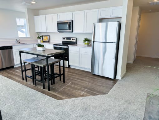 a kitchen with white cabinets and a stainless steel refrigerator
