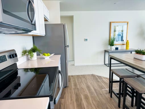 a kitchen and dining room with stainless steel appliances and a wooden floor