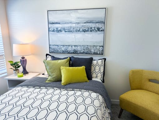 a bedroom with a bed and a yellow chair
