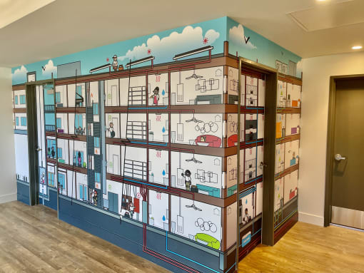a room with a wall mural of a building with bikes on it