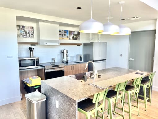 a view of a kitchen with a large island and green bar stools