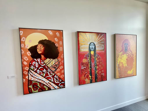 three paintings hanging on a wall in a museum