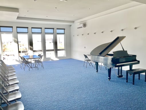 a piano in a room with chairs and a table