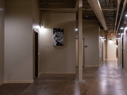 A long hallway with a black and white picture on the wall.