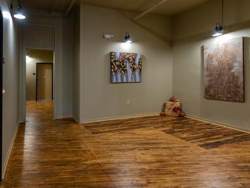A room with wooden floors and two paintings on the wall.