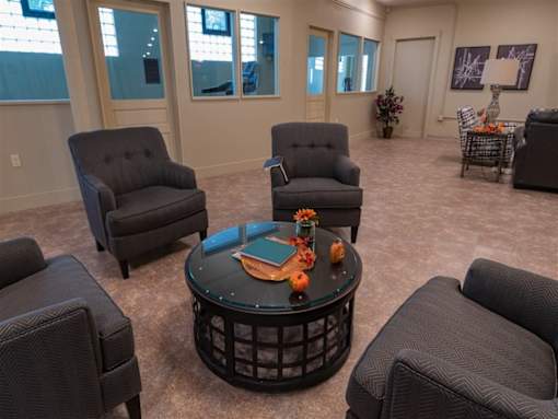 A living room with grey chairs and a black coffee table.