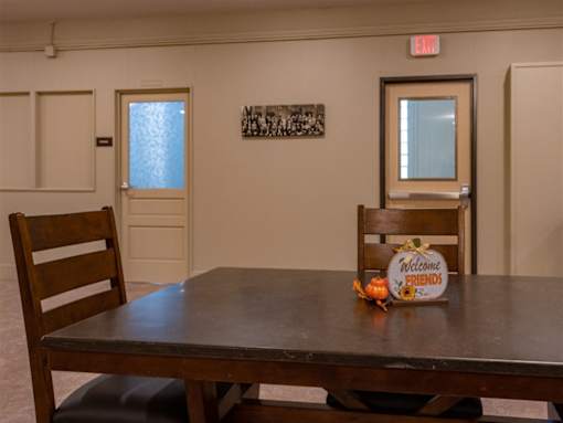 A wooden table with a sign that says "Welcome Friends" on it.
