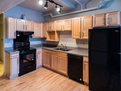 A kitchen with wooden cabinets and black appliances.