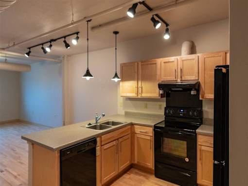 A kitchen with wooden cabinets and black appliances.