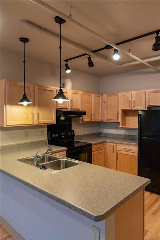 A kitchen with wooden cabinets and black appliances.