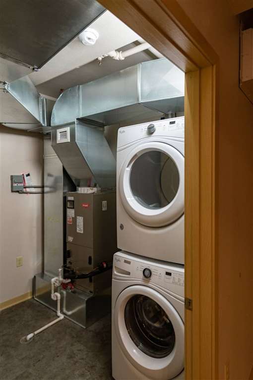 A view of a laundry room with a washer and dryer stacked on top of each other.