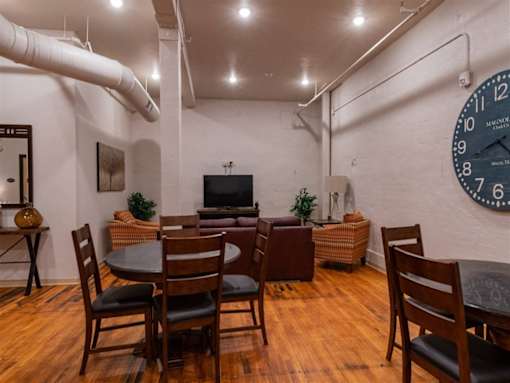 A living room with a large clock on the wall.