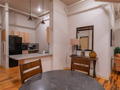 A kitchen with a black fridge and a wooden table.