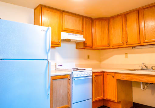 a kitchen with wooden cabinets and a blue refrigerator