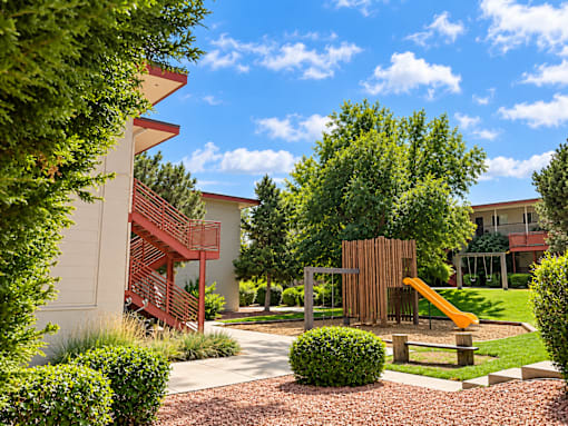 A playground area with a slide and a climbing structure.