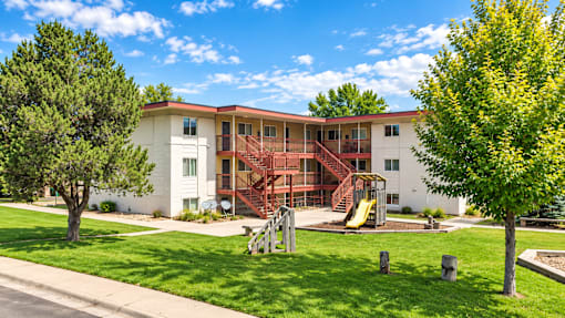 A white building with a red staircase in front of it.