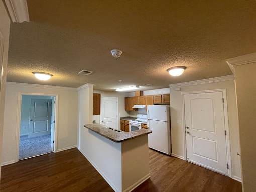 A kitchen with a refrigerator, cabinets, and a countertop.