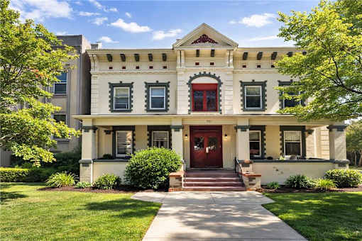 A white house with a red door and windows.