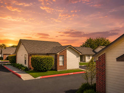 A row of houses with a sunset in the background.