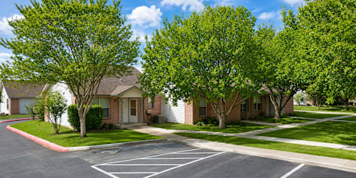 A row of houses with trees in front of them.