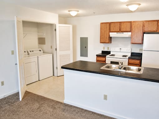 A kitchen with white cabinets and a black countertop.
