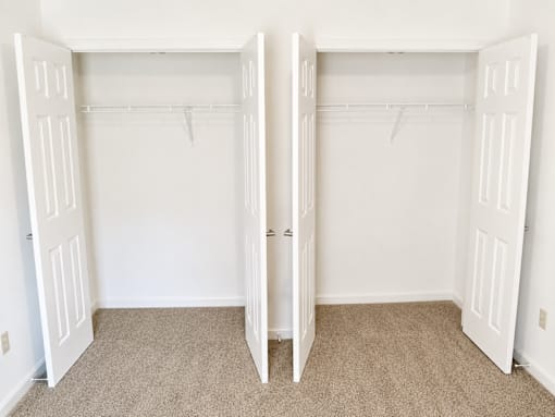 A room with two open white closets.