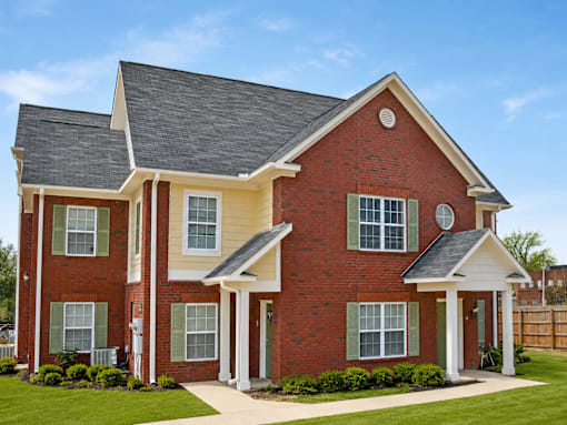 A red brick house with a white porch.