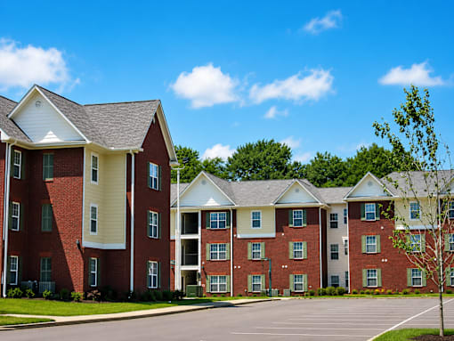 Apartment building with a parking lot in front.