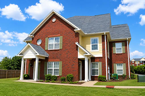 A red brick house with a white porch.