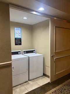 A sign is on the wall above the washing machine.