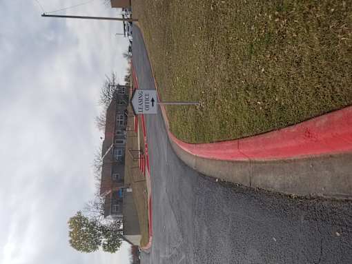 A street view with a red curb and a sign that says "No Parking".
