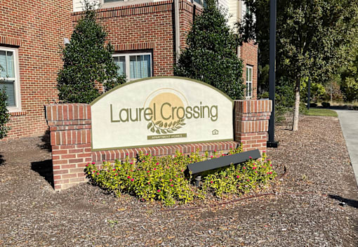the sign in front of the leasing office of laurel crossing apartments