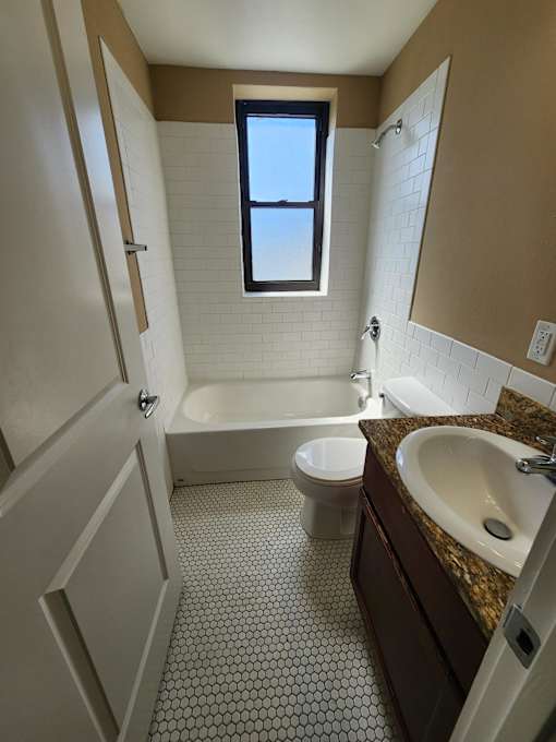 A bathroom with a toilet, sink, and bathtub.