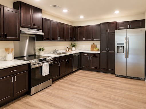 A kitchen with dark wood cabinets and stainless steel appliances.