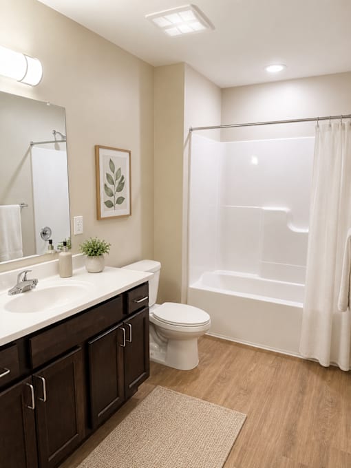 A bathroom with a toilet, sink, and shower.
