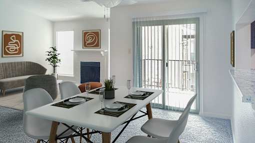 A dining room with a white table and chairs.